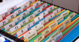 organizing paperwork in home office file cabinet